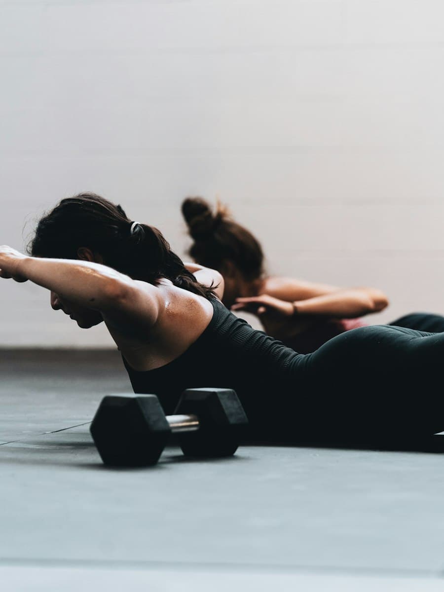 Duas pessoas treinando lado a lado no chão de um estúdio
