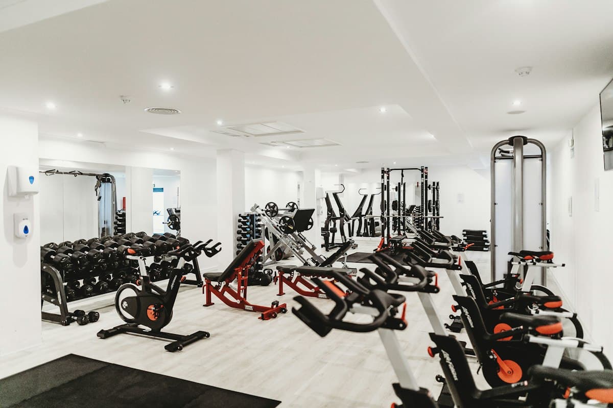 Sala de uma academia com bicicletas e aparelhos de musculação